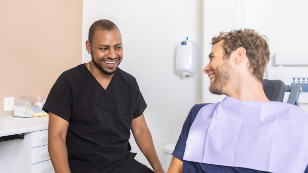 Dentist and patient sharing a laugh together in a dental office.






